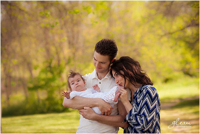 Family with baby with yellow trees in the background