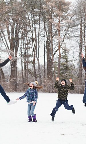 Fun Family portrait in wintertime with everyone jumping up in the air