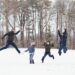 Fun Family portrait in wintertime with everyone jumping up in the air