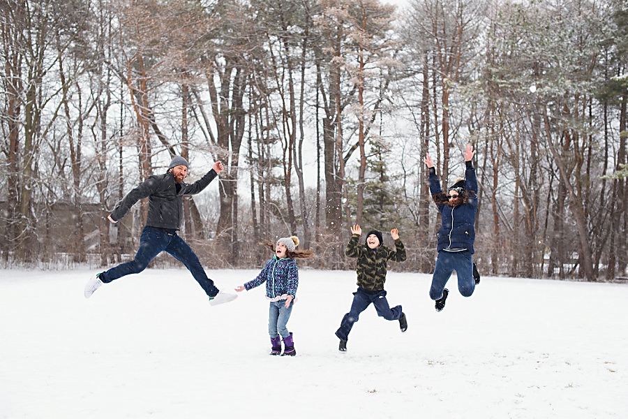 Fun Family portrait in wintertime with everyone jumping up in the air